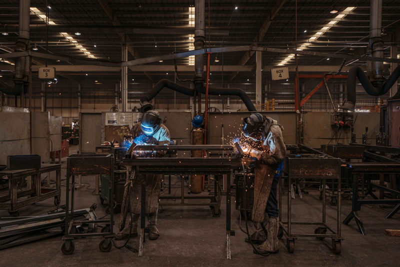 Soldadores trabalhando no chão de fábrica