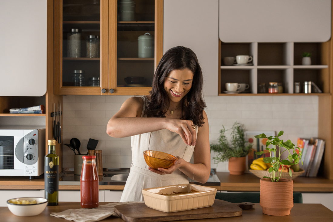 Mulher preparando uma refeição em cozinha com mobiliário Bertolini Móveis