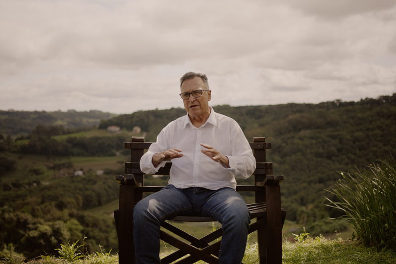Enólogo sentado diante das colinas de parreiras