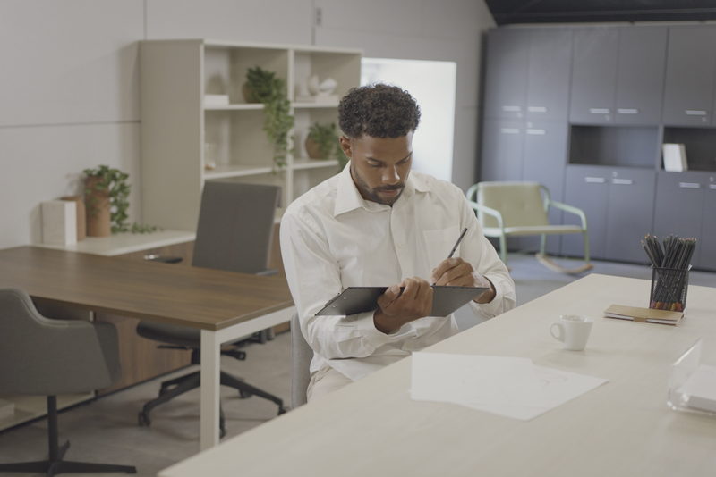 Profissional escrevendo à mão em ambiente de trabalho
